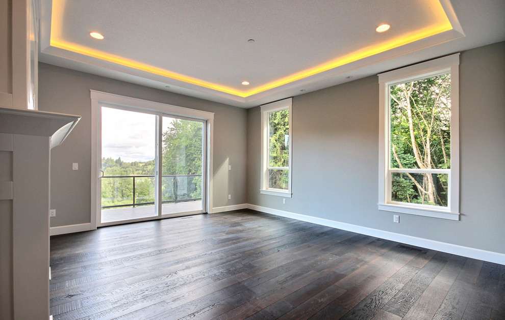 This is an example of an expansive classic master bedroom in Portland with grey walls, dark hardwood flooring, a standard fireplace, a tiled fireplace surround and brown floors.