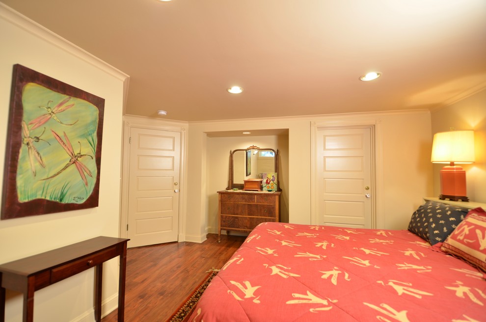 Example of a mid-sized transitional guest medium tone wood floor bedroom design in Portland with beige walls