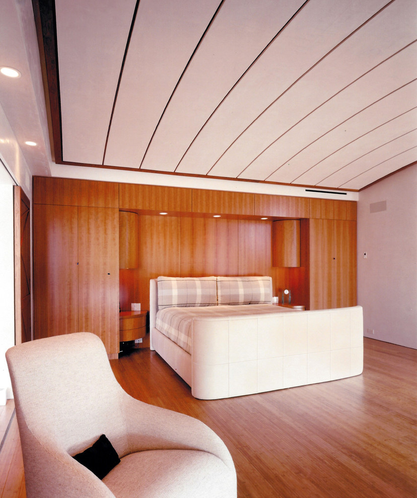Ejemplo de habitación de invitados contemporánea grande sin chimenea con paredes beige, suelo de madera en tonos medios y suelo marrón
