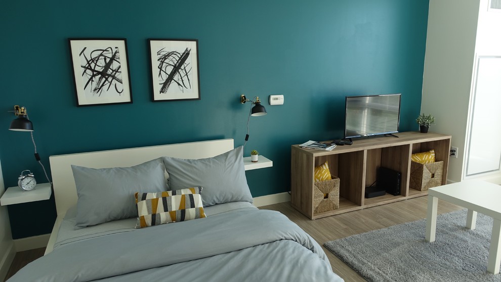 Inspiration pour une petite chambre d'amis design avec un mur bleu.