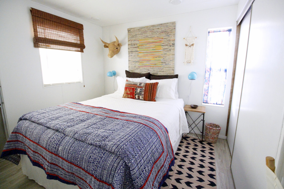 Imagen de dormitorio principal bohemio de tamaño medio con paredes blancas, suelo vinílico y suelo gris