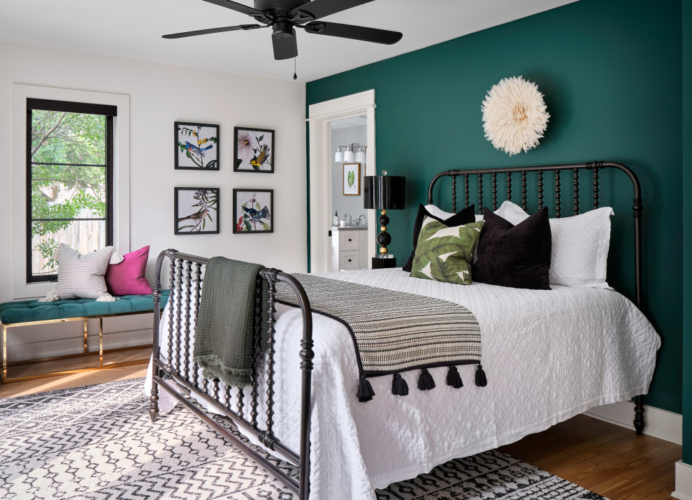 Classic grey and pink bedroom in Austin with green walls, medium hardwood flooring and brown floors.