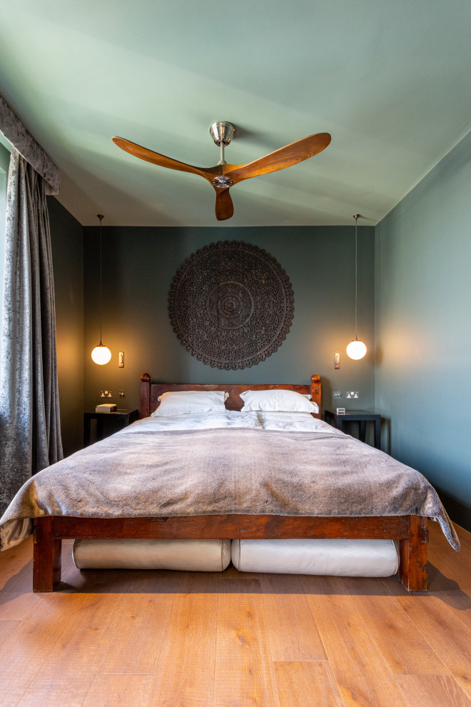 Foto de dormitorio principal contemporáneo con paredes azules y suelo de madera clara