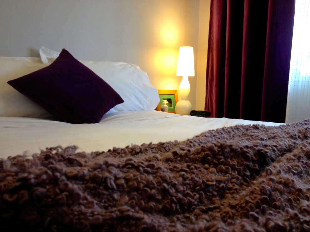 Imagen de habitación de invitados contemporánea pequeña con paredes púrpuras y suelo de madera oscura