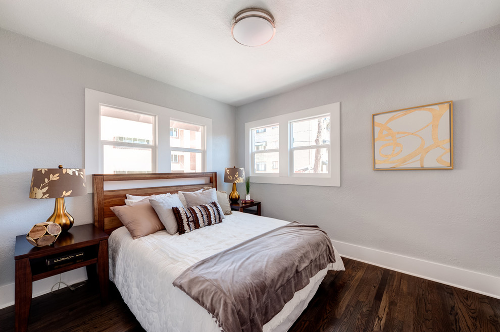 Idée de décoration pour une chambre d'amis minimaliste de taille moyenne avec un mur blanc et parquet foncé.
