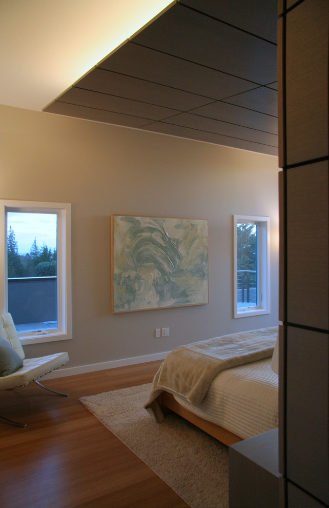 Ejemplo de dormitorio principal minimalista grande sin chimenea con paredes beige y suelo de bambú