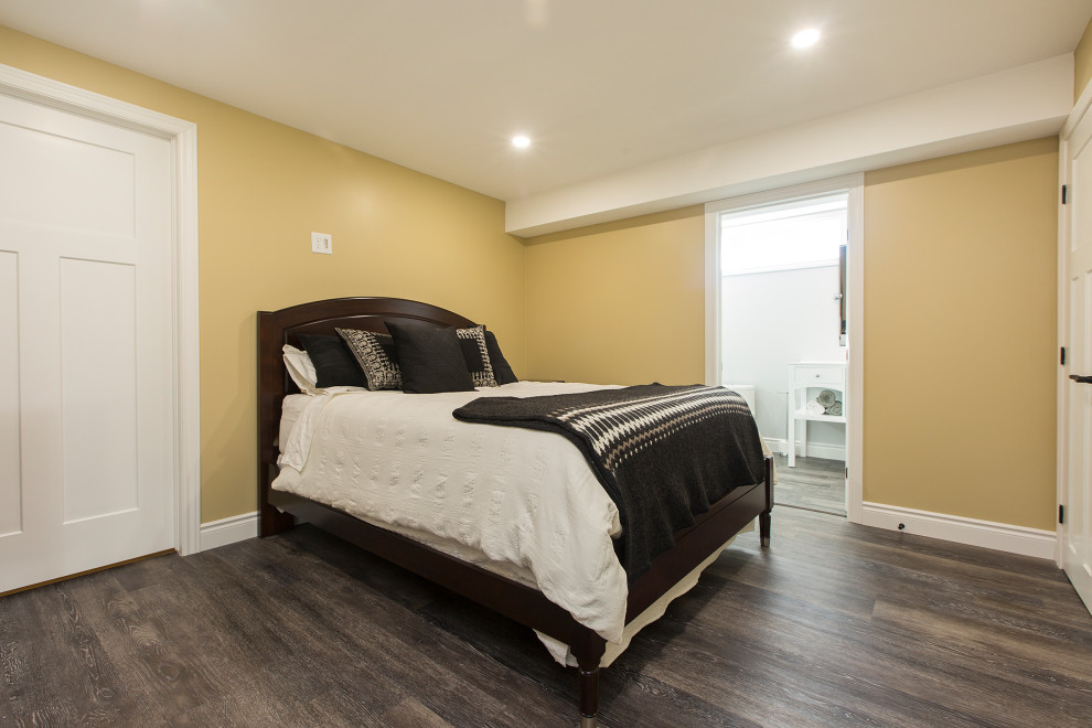 Ejemplo de dormitorio tradicional de tamaño medio sin chimenea con paredes amarillas, suelo vinílico y suelo marrón