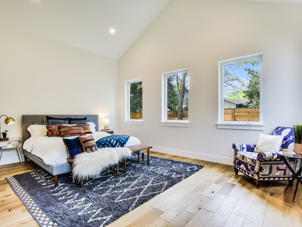 Diseño de dormitorio contemporáneo sin chimenea con paredes blancas, suelo de madera en tonos medios y suelo beige