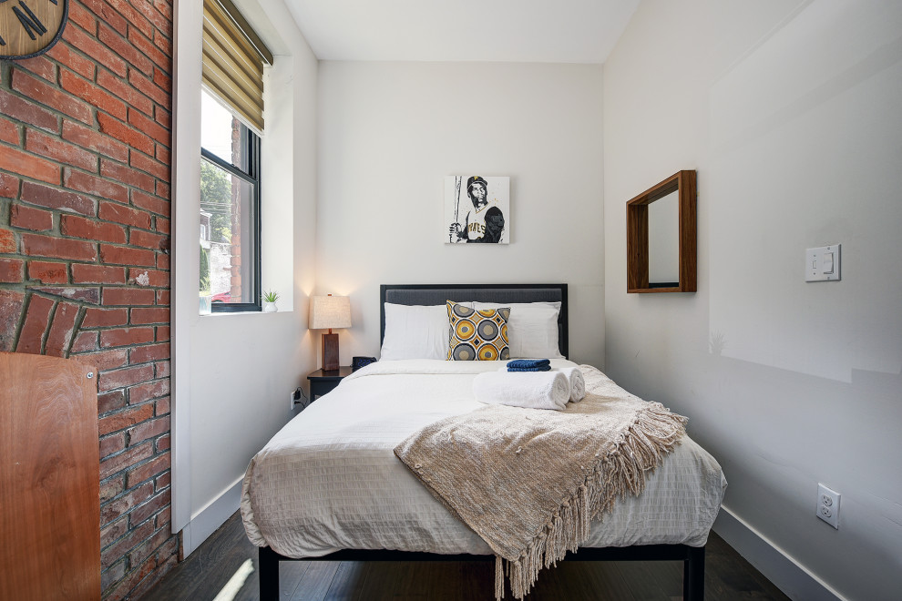 Kleines Modernes Gästezimmer ohne Kamin mit weißer Wandfarbe, dunklem Holzboden und braunem Boden in Sonstige