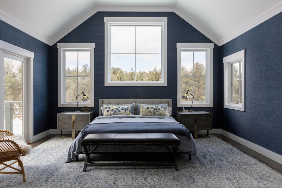 Idée de décoration pour une grande chambre parentale tradition avec un mur bleu, un sol marron et parquet foncé.