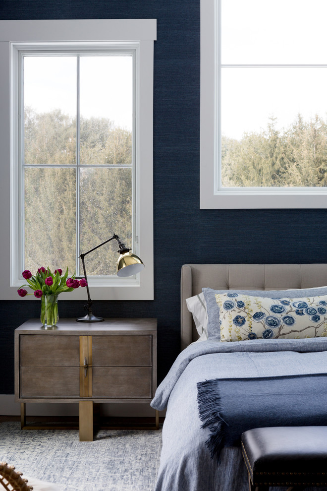 ニューヨークにある広いトランジショナルスタイルのおしゃれな主寝室 (青い壁、淡色無垢フローリング、吊り下げ式暖炉、タイルの暖炉まわり、茶色い床)