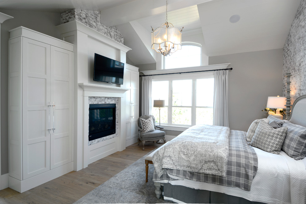 Свежая идея для дизайна: большая хозяйская спальня в стиле неоклассика (современная классика) с серыми стенами, светлым паркетным полом, стандартным камином и фасадом камина из дерева - отличное фото интерьера