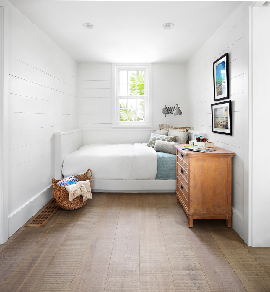 Kleines Maritimes Schlafzimmer mit weißer Wandfarbe und braunem Holzboden in Sonstige