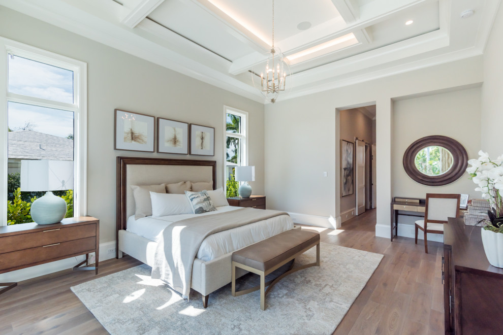 Diseño de dormitorio principal clásico de tamaño medio sin chimenea con paredes beige, suelo de madera clara y suelo marrón