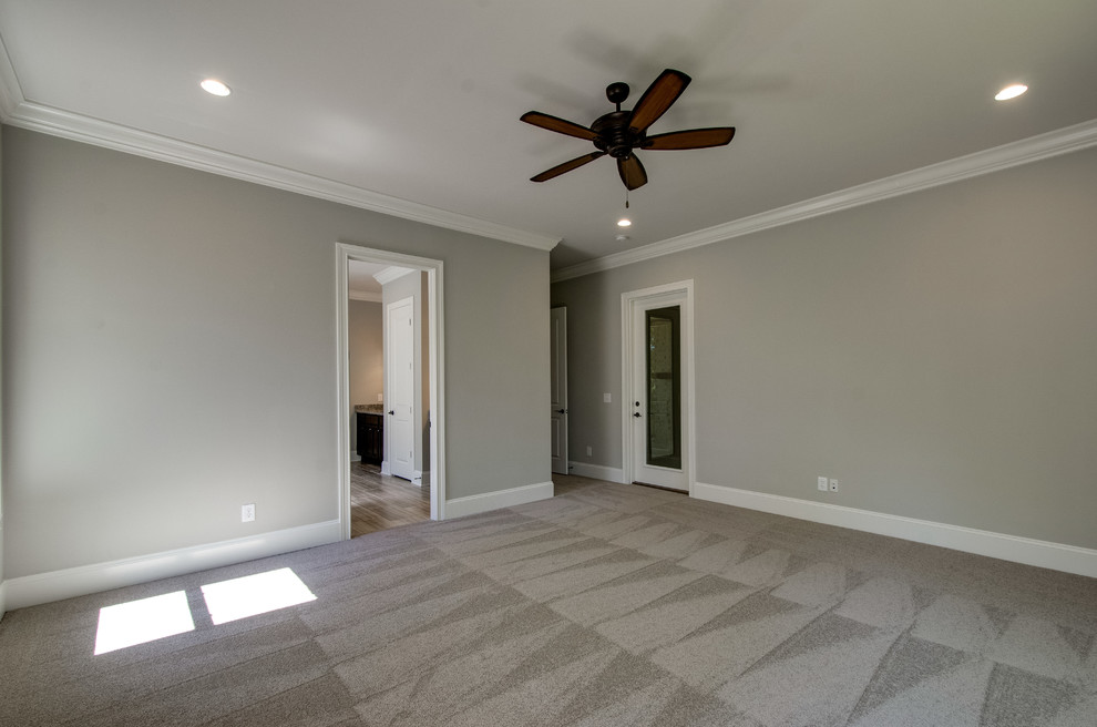This is an example of a large traditional master bedroom in Nashville with beige walls and carpet.