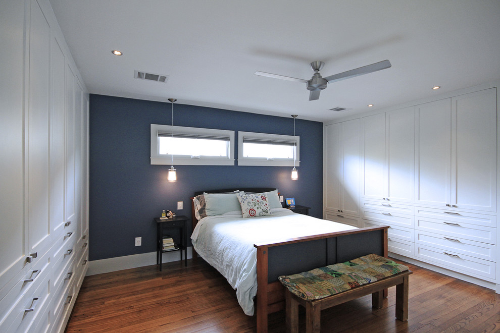 Exemple d'une chambre parentale chic de taille moyenne avec un mur bleu, un sol en bois brun, aucune cheminée et un sol marron.