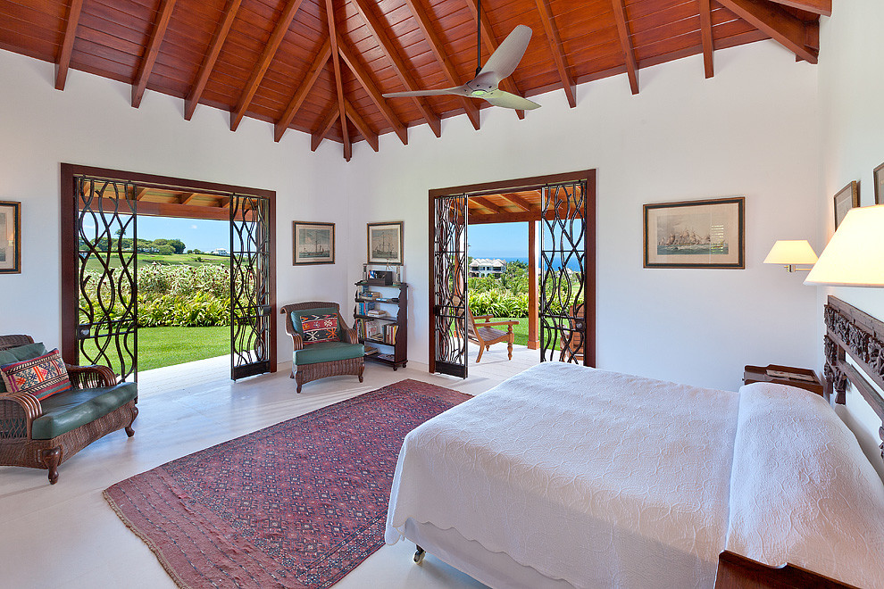 Imagen de dormitorio principal tropical con paredes blancas