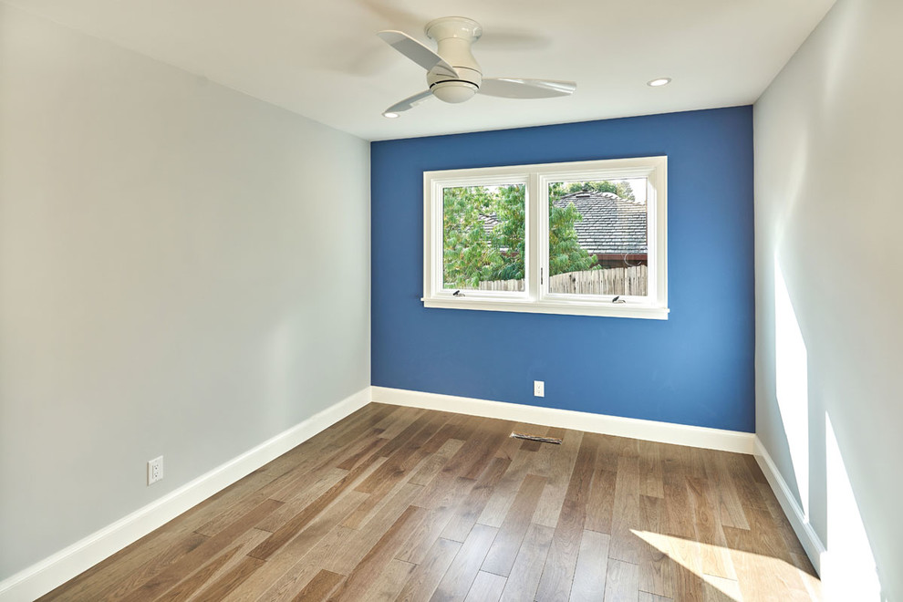 На фото: спальня в стиле неоклассика (современная классика) с синими стенами и темным паркетным полом с