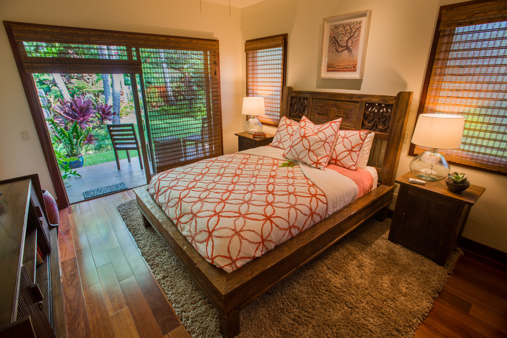 Inspiration for a mid-sized tropical guest dark wood floor bedroom remodel in Hawaii with beige walls