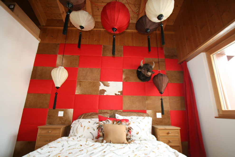 Cette photo montre une chambre d'amis éclectique de taille moyenne avec un mur rouge et un sol en bois brun.