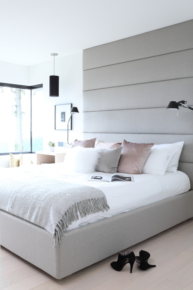 Großes Modernes Hauptschlafzimmer mit weißer Wandfarbe, hellem Holzboden, Kamin und Kaminumrandung aus Stein in Vancouver