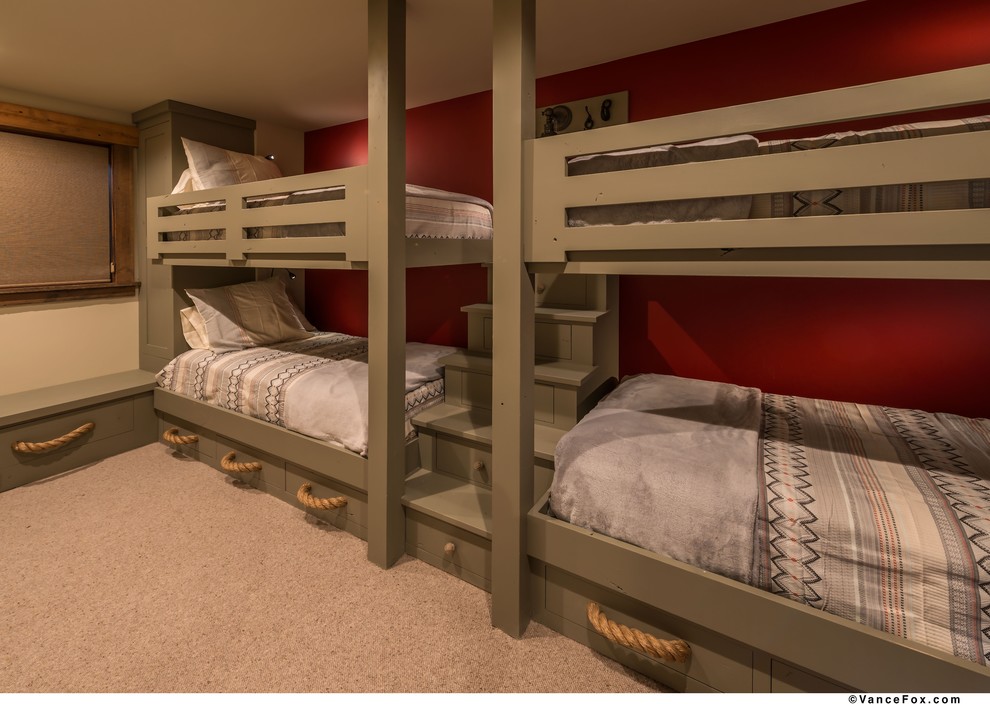 This is an example of a rustic guest bedroom in Other with red walls and carpet.