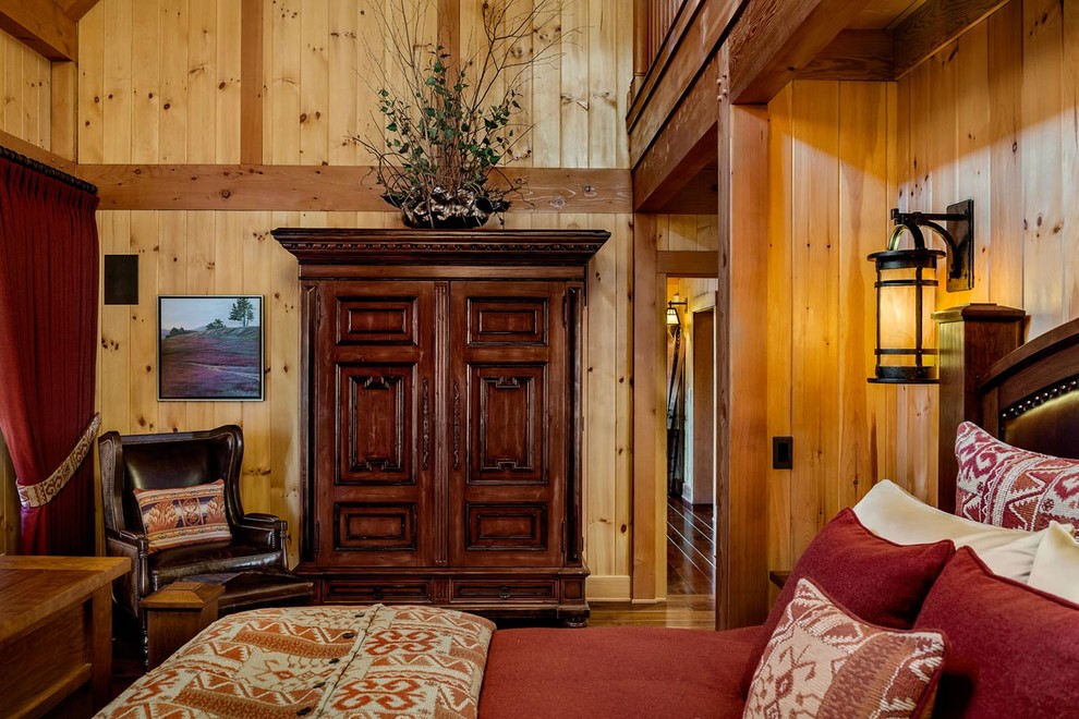 На фото: большая хозяйская спальня в стиле рустика с коричневыми стенами и темным паркетным полом без камина