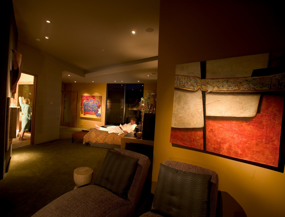 На фото: большая хозяйская спальня в современном стиле с разноцветными стенами, ковровым покрытием, угловым камином и фасадом камина из камня с