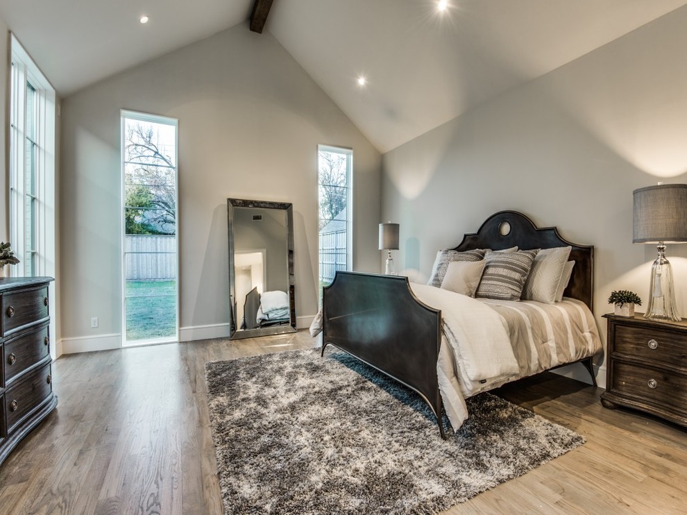 Ejemplo de dormitorio principal tradicional renovado grande con paredes grises y suelo de madera clara