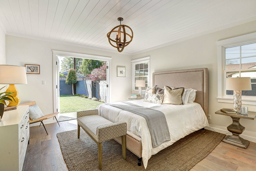 Idée de décoration pour une chambre parentale tradition de taille moyenne avec un mur beige et un sol en bois brun.