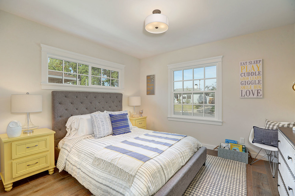 Modelo de dormitorio clásico renovado con paredes beige y suelo de madera en tonos medios