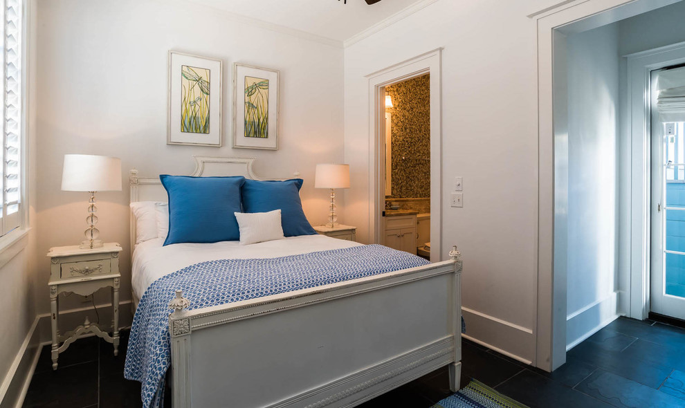 Large coastal guest bedroom in Miami with white walls, dark hardwood flooring and brown floors.