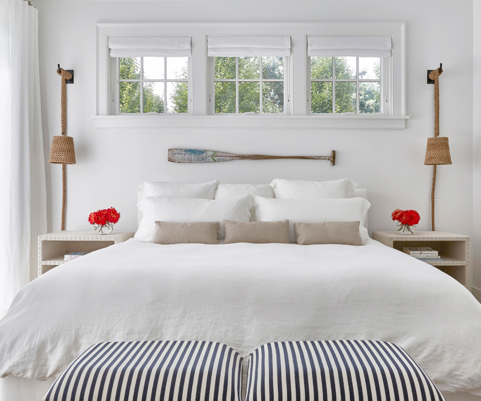 ニューヨークにある広いコンテンポラリースタイルのおしゃれな客用寝室 (白い壁、淡色無垢フローリング、標準型暖炉、漆喰の暖炉まわり) のインテリア