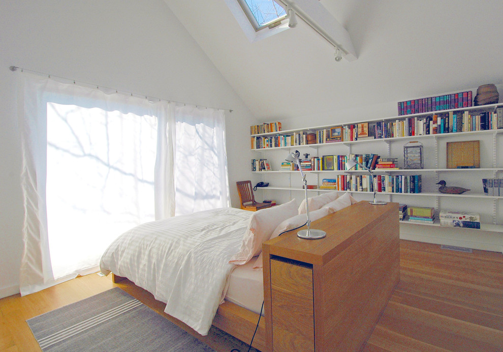 Immagine di una camera degli ospiti moderna di medie dimensioni con pareti bianche, parquet chiaro e nessun camino
