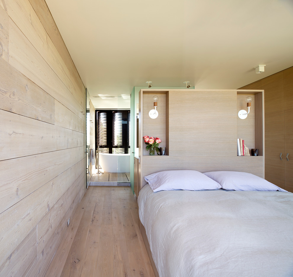 Photo of a medium sized beach style master bedroom in New York with light hardwood flooring.