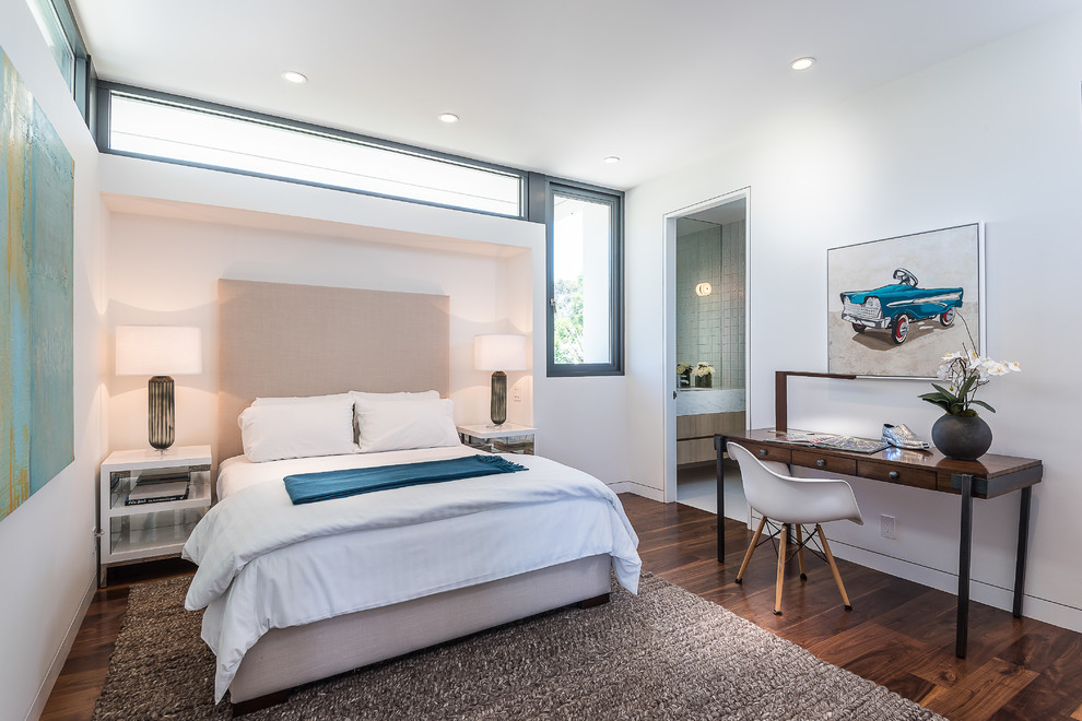 This is an example of a medium sized modern guest bedroom in Los Angeles with white walls and dark hardwood flooring.