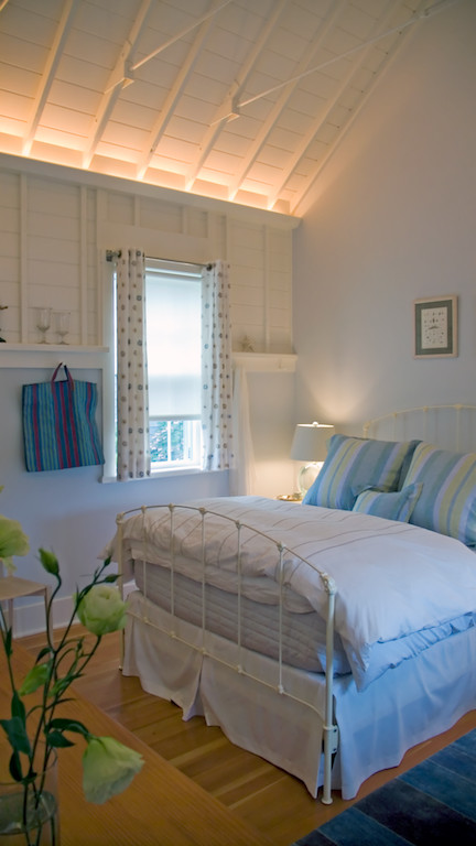 Foto di una piccola camera degli ospiti design con pareti bianche e pavimento in legno massello medio