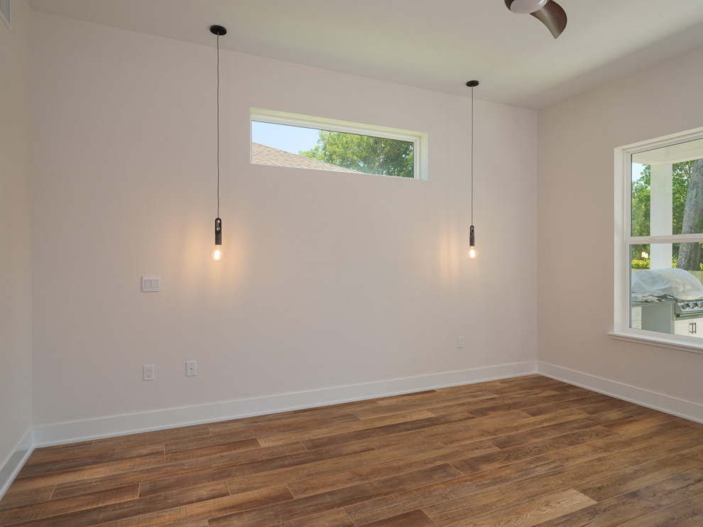 Idée de décoration pour une chambre parentale design avec un mur blanc, un sol en vinyl et un sol marron.