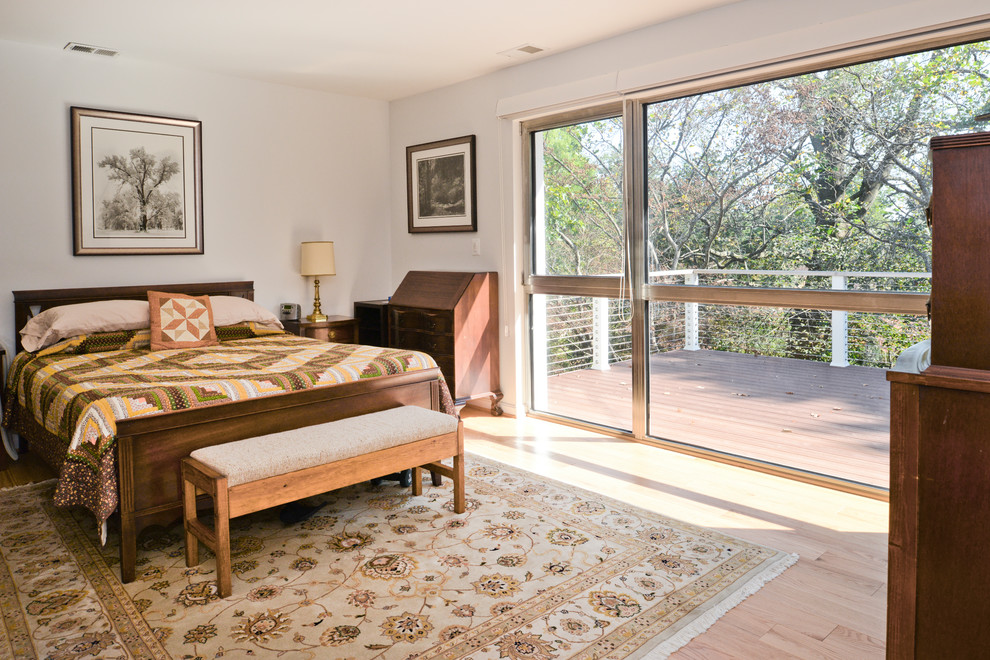 Cette photo montre une très grande chambre parentale moderne avec un mur blanc, parquet clair et un sol marron.