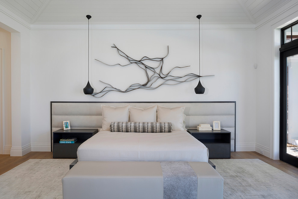 マイアミにある広いコンテンポラリースタイルのおしゃれな主寝室 (白い壁、無垢フローリング、暖炉なし、茶色い床)
