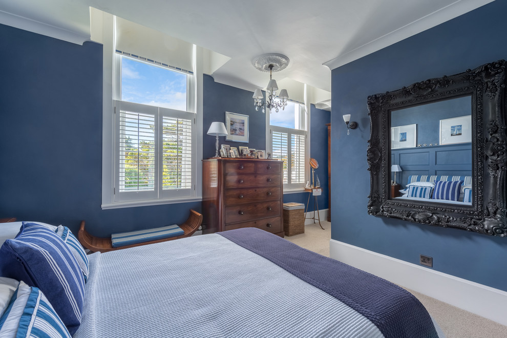 Mittelgroßes Modernes Hauptschlafzimmer mit blauer Wandfarbe und Teppichboden in Devon