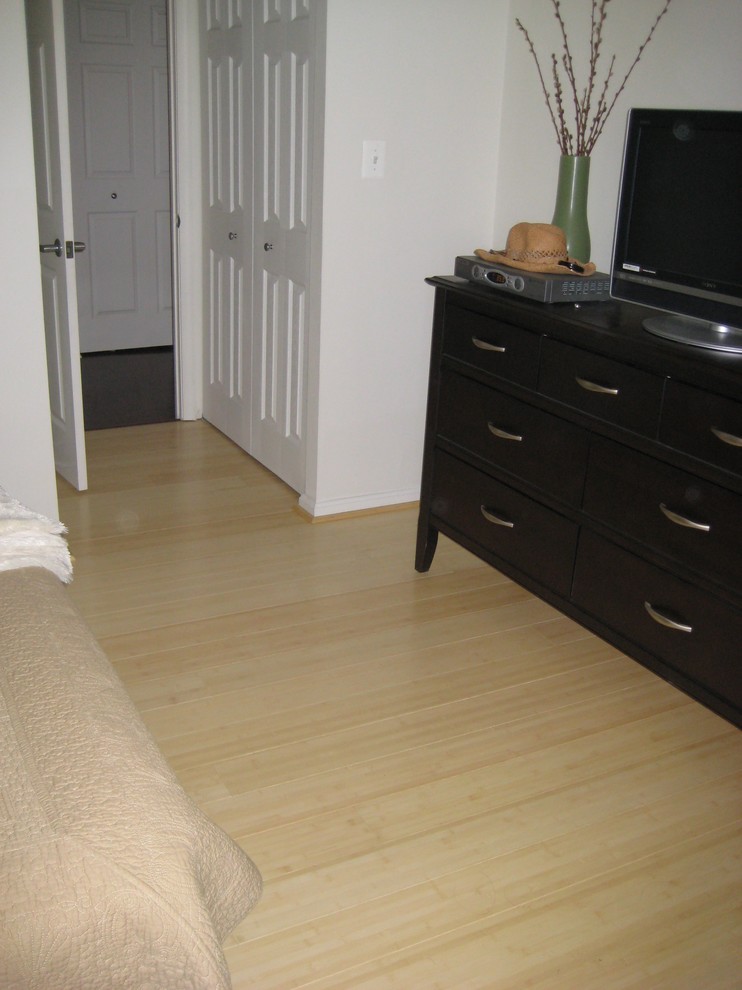 Foto på ett sovrum, med bambugolv och gult golv