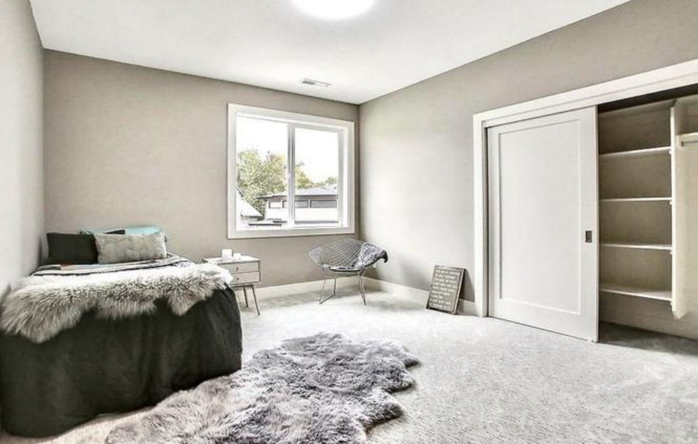 Modern inredning av ett mellanstort sovrum, med beige väggar, heltäckningsmatta och grått golv