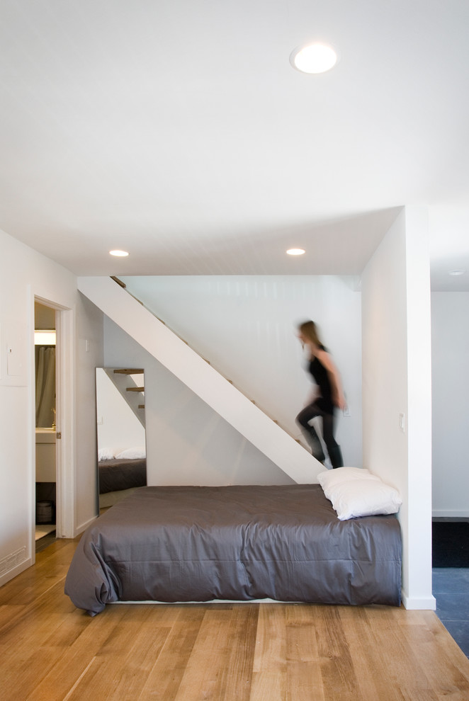 Cette image montre une chambre minimaliste avec un mur blanc.