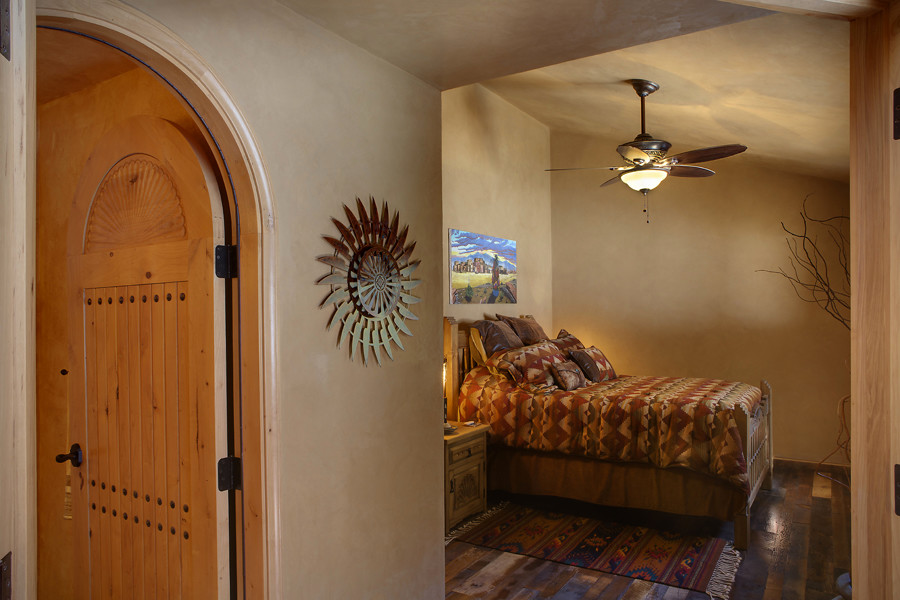 デンバーにある中くらいなサンタフェスタイルのおしゃれな客用寝室 (ベージュの壁、濃色無垢フローリング)