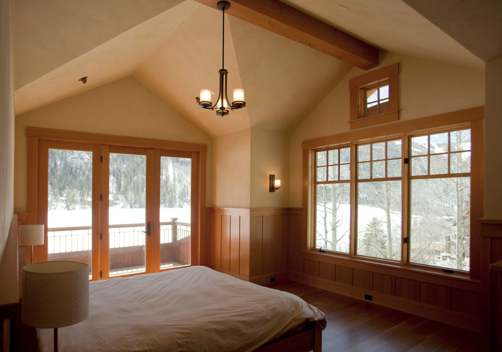 Aménagement d'une chambre parentale craftsman de taille moyenne avec un mur beige, un sol en bois brun et aucune cheminée.