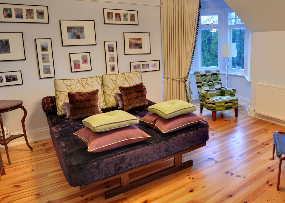 Ispirazione per una camera da letto boho chic con pareti viola e pavimento in legno massello medio