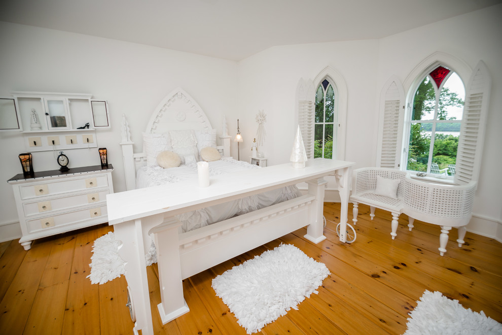 Imagen de dormitorio principal ecléctico grande con paredes blancas, suelo de madera en tonos medios y suelo beige