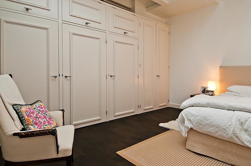 Foto de dormitorio principal escandinavo de tamaño medio sin chimenea con paredes blancas, suelo de madera oscura y suelo marrón