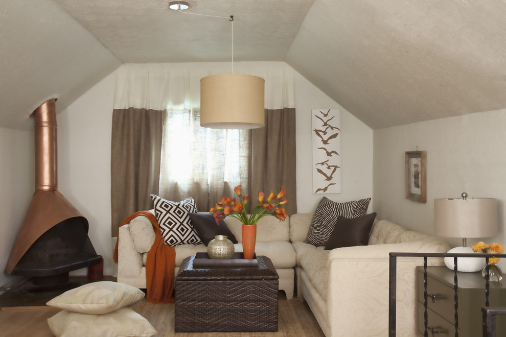 Idée de décoration pour une chambre bohème avec un mur beige, un sol en bois brun et un poêle à bois.